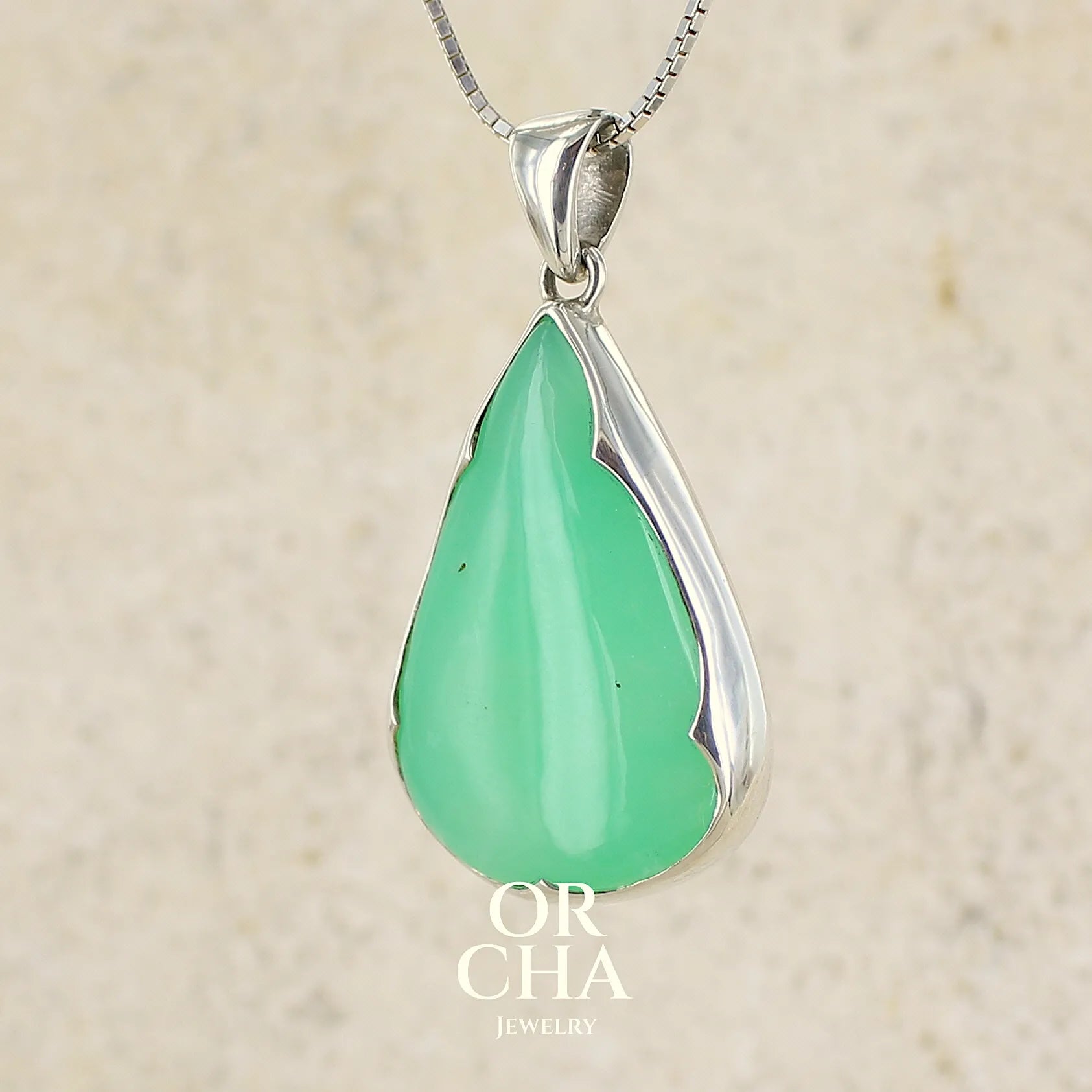 Pendentif pour femme en argent massif, sertie d'un cabochon de chrysoprase de couleur vert pomme. Cabochon de qualité translucide taillée en  forme de goutte. Bijoux unique par Orcha jewelry