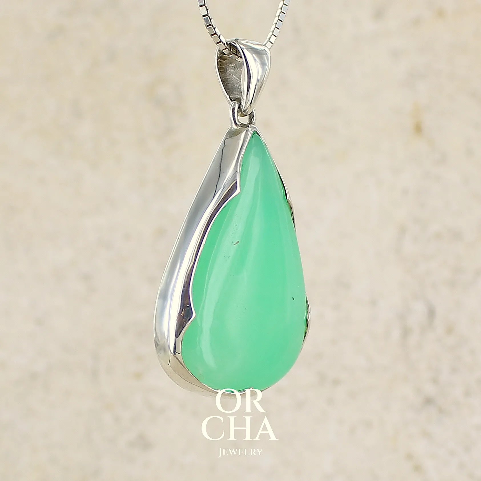 Pendentif pour femme en argent massif, sertie d'un cabochon de chrysoprase de couleur vert pomme. Cabochon de qualité translucide taillée en  forme de goutte. Bijoux unique par Orcha jewelry