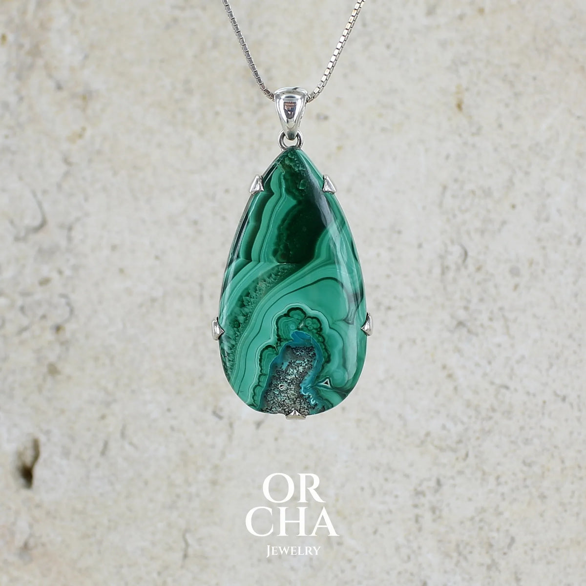 Grand pendentif pour femme en argent massif serti d'un cabochon de Malachite à très légère inclusion de Chrysocolle, camaïeu de couleur vert profond et intense. Pierre de qualité opaque taillée en forme de goutte. Bijoux unique réalisé par Orchajewelry