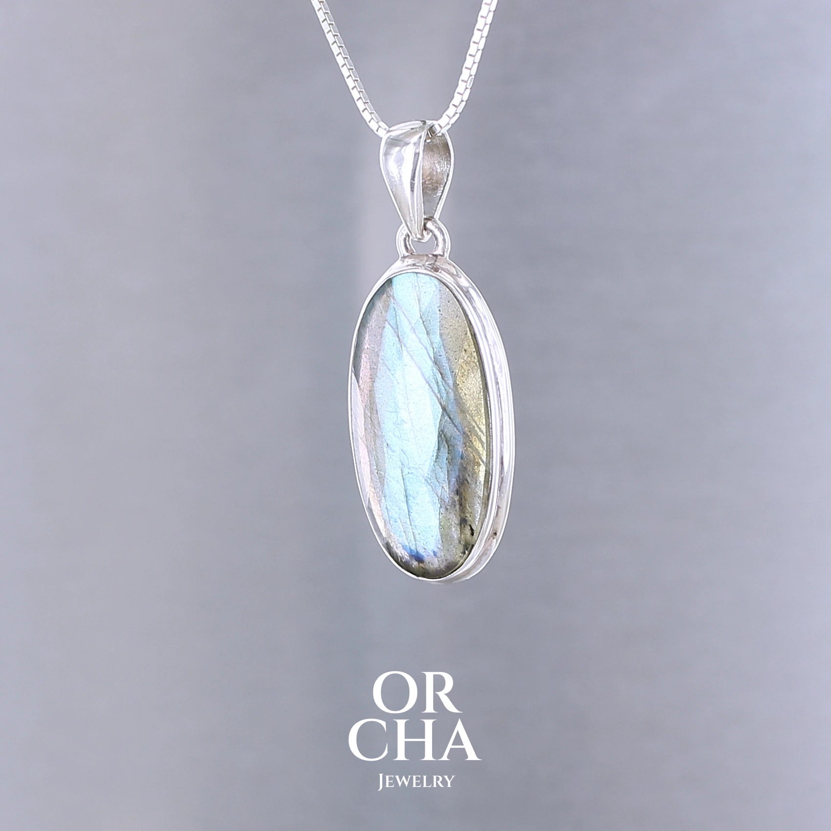 Pendentif pour femme en argent massif sertie d'une labradorite aux reflets bleus clairs selon la lumière. Pierre facettée naturelle translucide présentant des inclusions fréquents sur ce type de pierre. Bijoux unique, éthique et durable présenté dans un coffret de notre marque, prêt à offrir. Livraison offerte, certificat d'authenticité, service client.