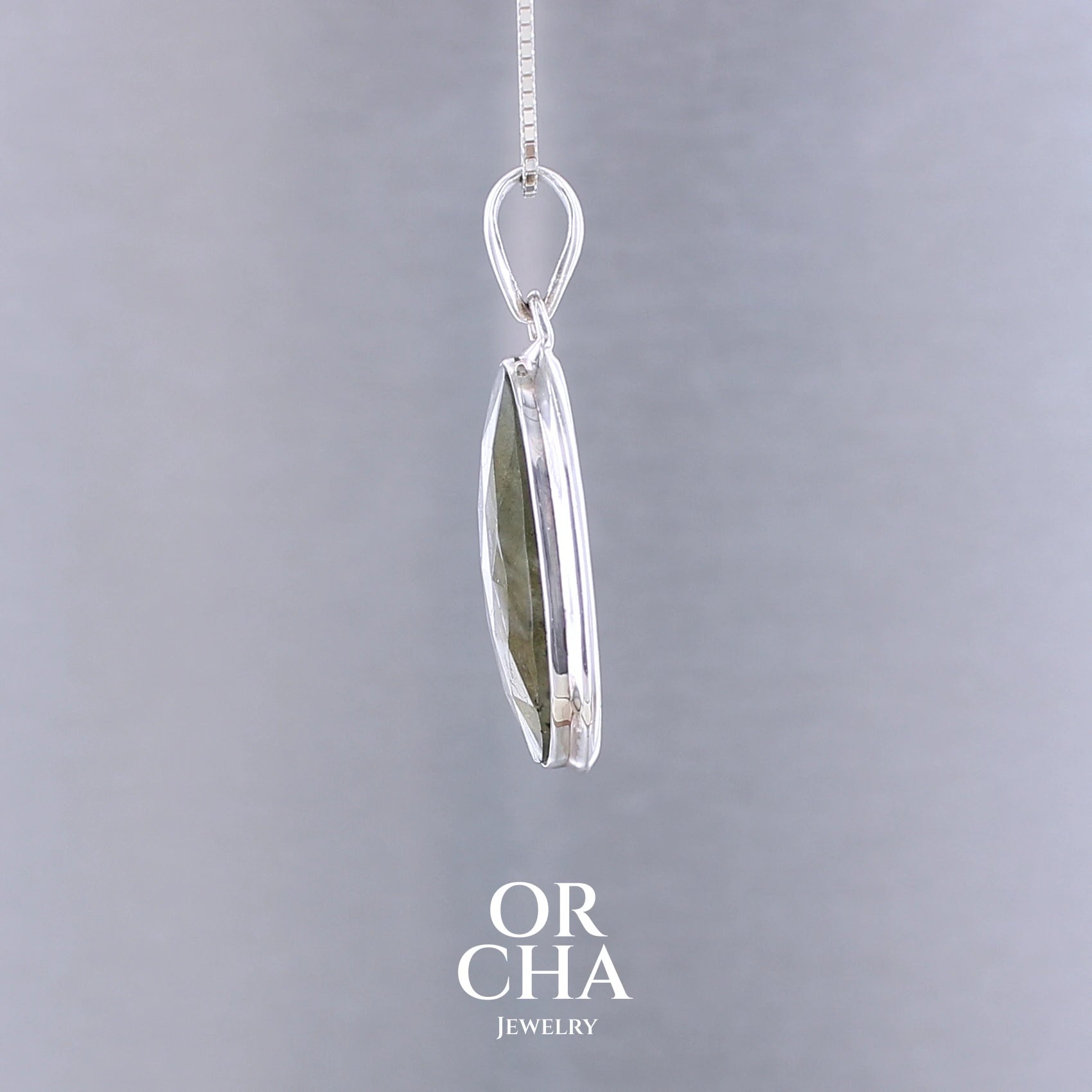 Pendentif pour femme en argent massif sertie d'une labradorite aux reflets bleus clairs selon la lumière. Pierre facettée naturelle translucide présentant des inclusions fréquents sur ce type de pierre. Bijoux unique, éthique et durable présenté dans un coffret de notre marque, prêt à offrir. Livraison offerte, certificat d'authenticité, service client.