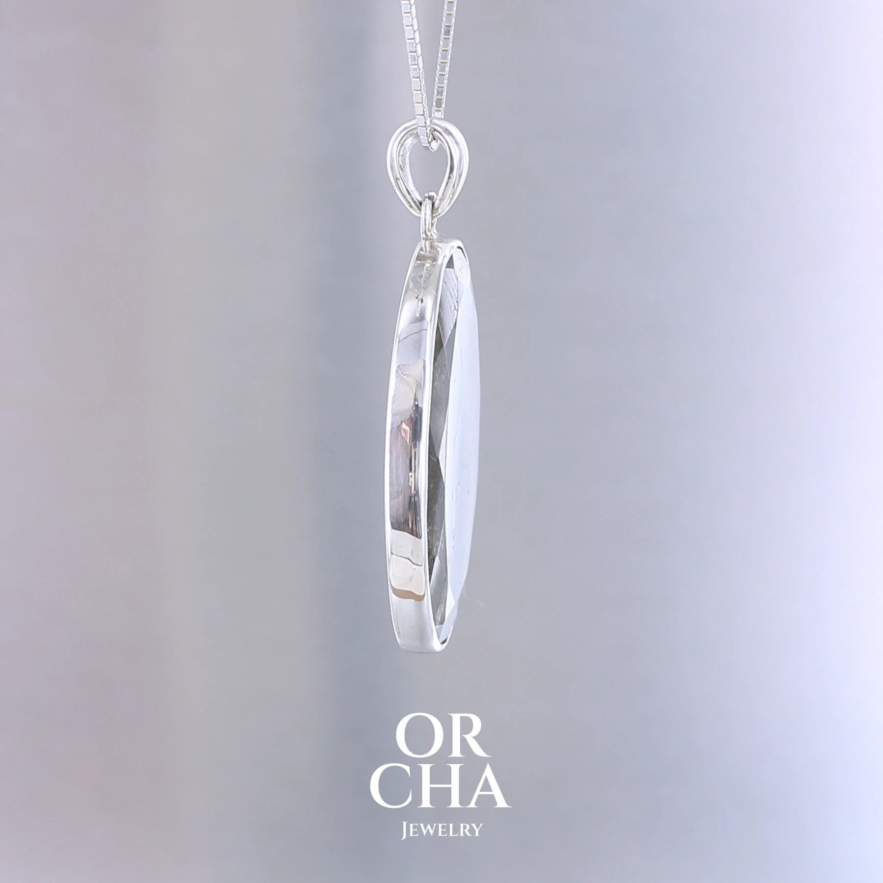 Pendentif ovale pour femme en argent massif serti d'une labradorite aux reflets bleus clairs, bleu vert selon la lumière. Pierre facettée naturelle translucide présentant des inclusions fréquents sur ce type de pierre. Bijoux unique, éthique et durable présenté dans un coffret de notre marque, prêt à offrir. Livraison offerte, certificat d'authenticité, service client.
