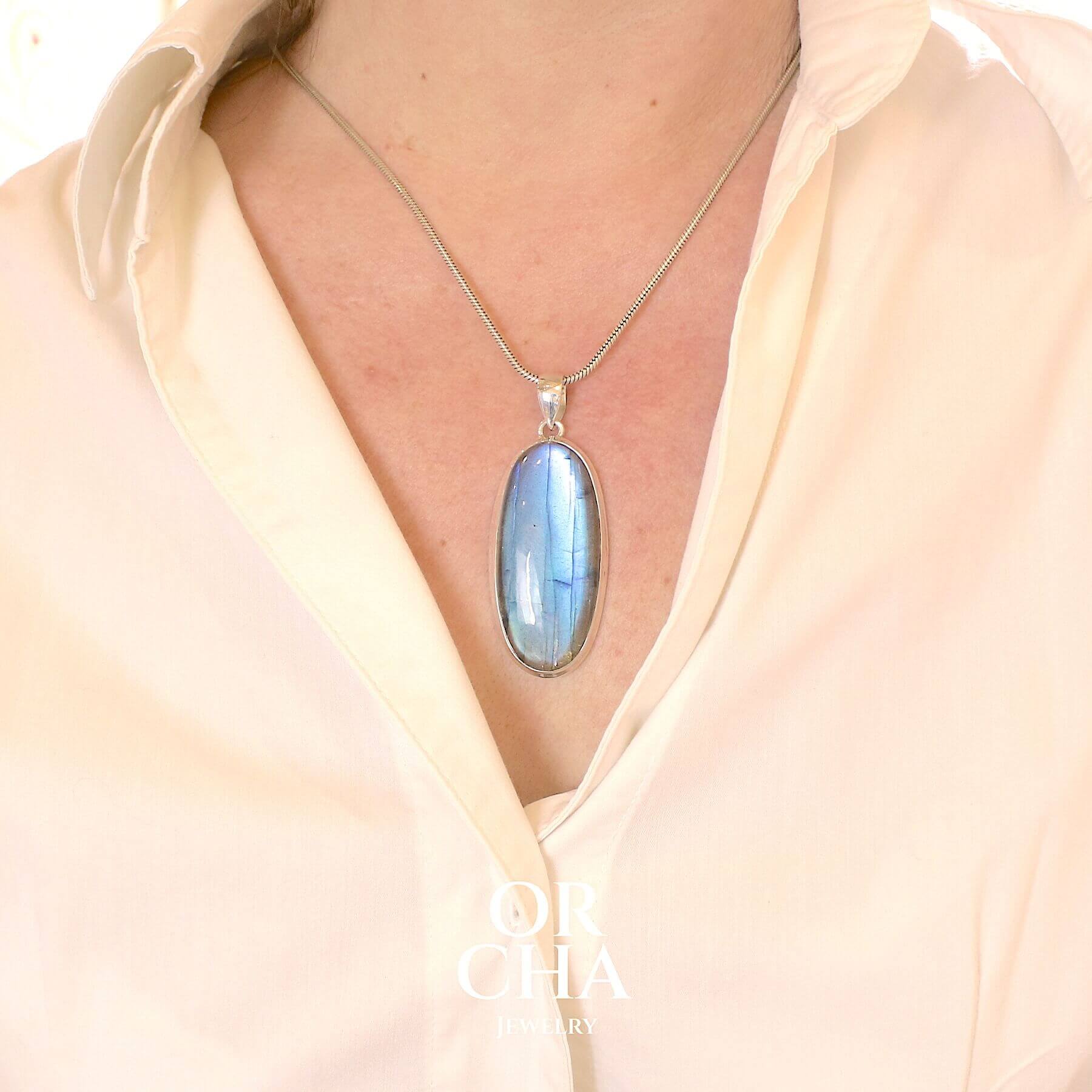 Pendentif ovale pour femme en argent massif sertie d'une labradorite aux reflets bleus électrique. Pierre cabochon naturelle translucide présentant des inclusions fréquents sur ce type de pierre. Bijoux unique, éthique et durable présenté dans un coffret de notre marque, prêt à offrir. Livraison offerte, certificat d'authenticité, service client.