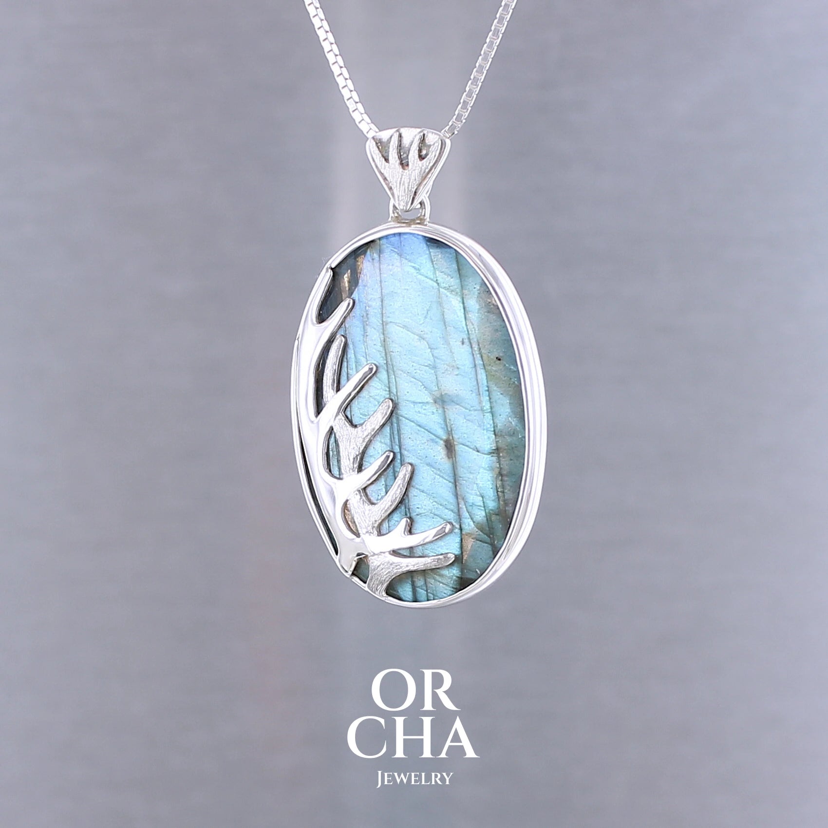 Pendentif pour femme en argent massif sertie d'une labradorite aux reflets bleus, Une ramure de cerf sculptée en argent penchasse la pierre. Pierre facettée naturelle translucide présentant des inclusions fréquents sur ce type de pierre. Bijoux unique, éthique et durable présenté dans un coffret de notre marque, prêt à offrir. Livraison offerte, certificat d'authenticité, service client.
