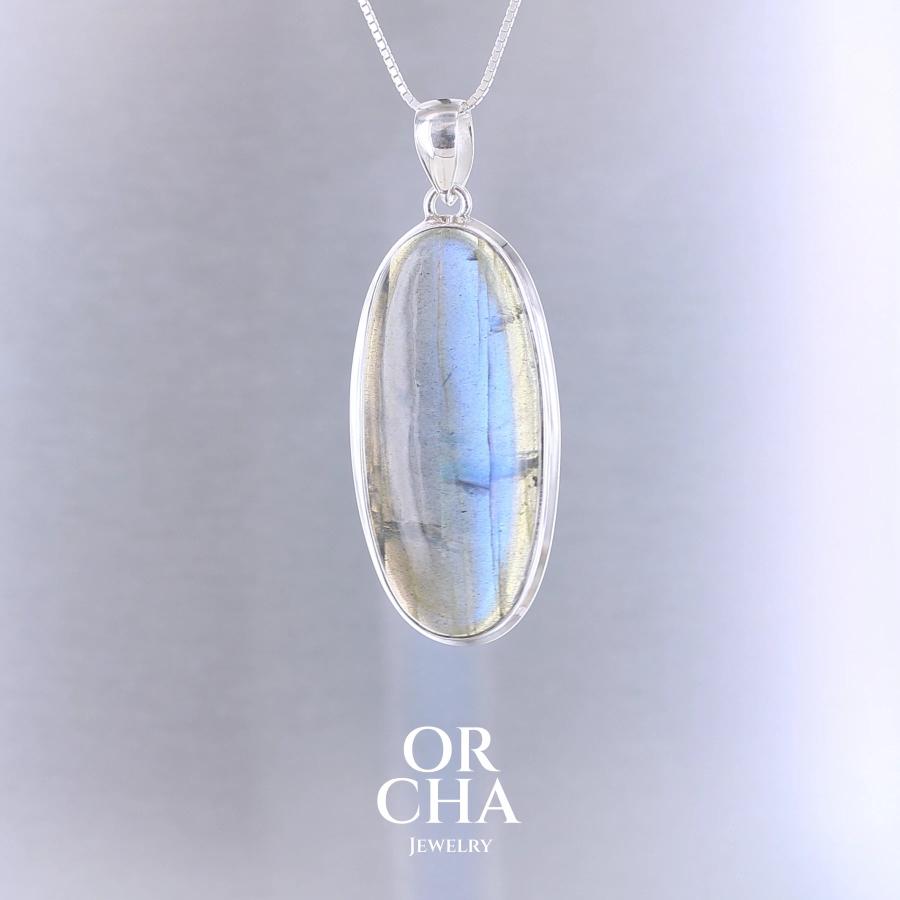 Pendentif ovale pour femme en argent massif sertie d'une labradorite aux reflets bleus électrique. Pierre cabochon naturelle translucide présentant des inclusions fréquents sur ce type de pierre. Bijoux unique, éthique et durable présenté dans un coffret de notre marque, prêt à offrir. Livraison offerte, certificat d'authenticité, service client.