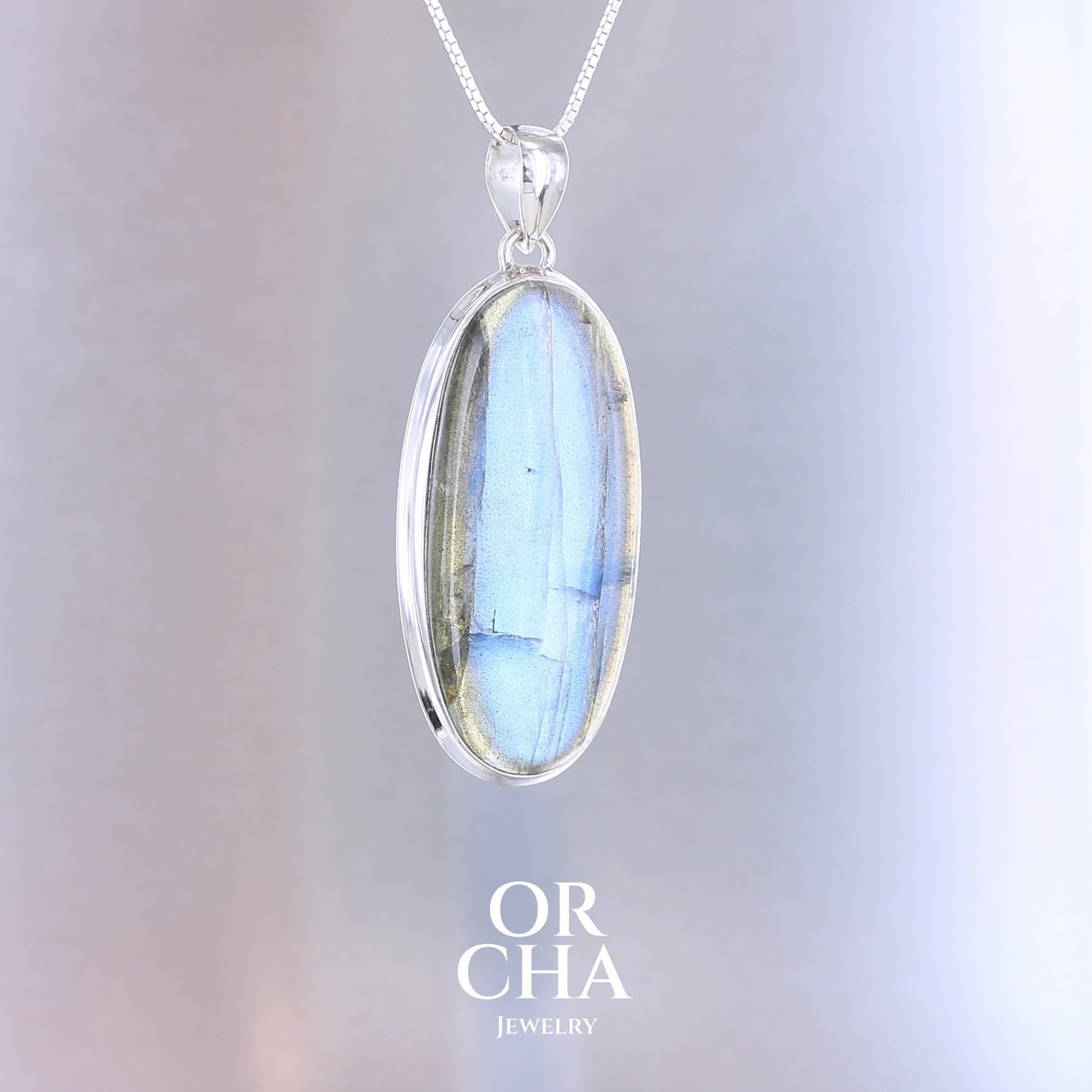 Pendentif ovale pour femme en argent massif sertie d'une labradorite aux reflets bleus électrique. Pierre cabochon naturelle translucide présentant des inclusions fréquents sur ce type de pierre. Bijoux unique, éthique et durable présenté dans un coffret de notre marque, prêt à offrir. Livraison offerte, certificat d'authenticité, service client.
