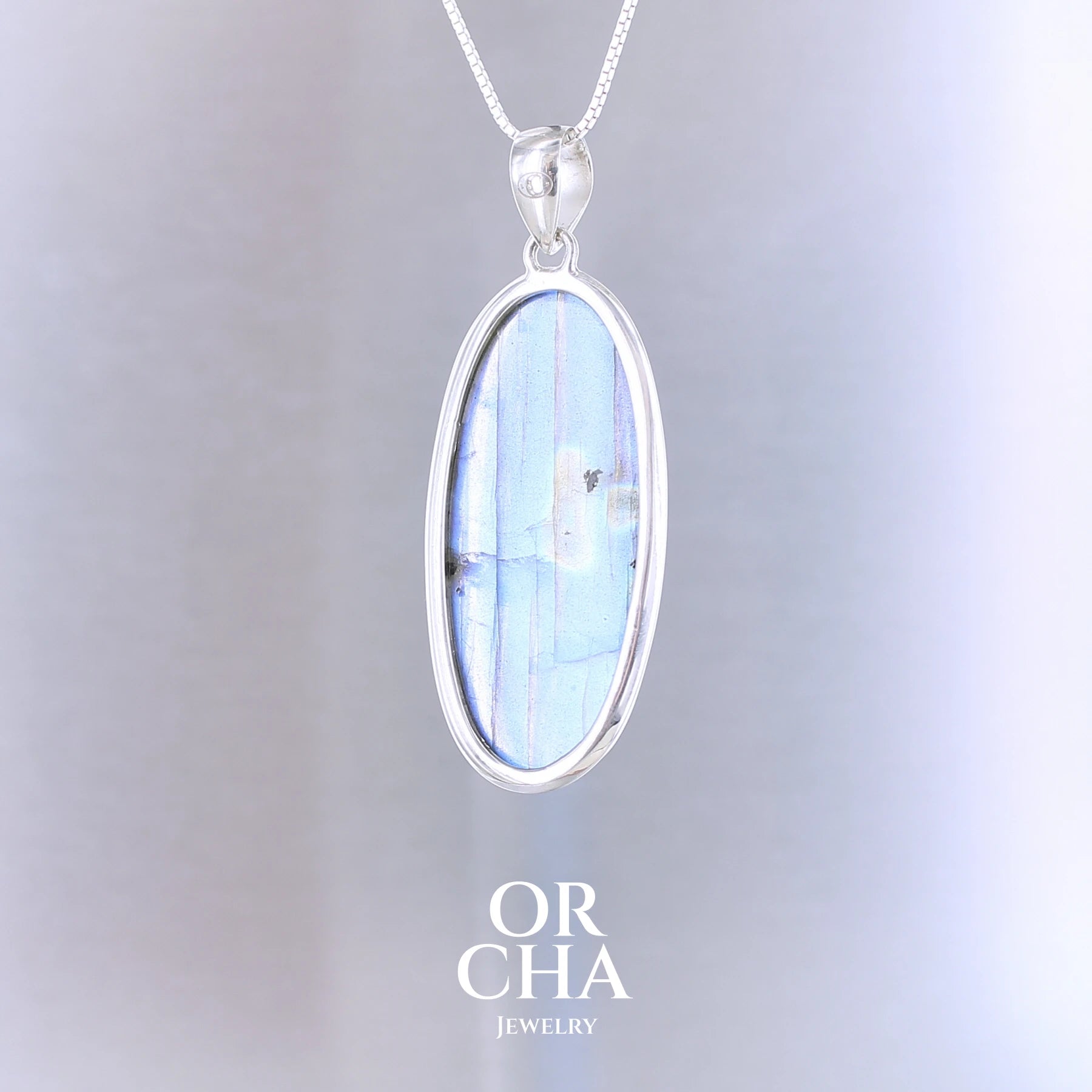 Pendentif ovale pour femme en argent massif sertie d'une labradorite aux reflets bleus électrique. Pierre cabochon naturelle translucide présentant des inclusions fréquents sur ce type de pierre. Bijoux unique, éthique et durable présenté dans un coffret de notre marque, prêt à offrir. Livraison offerte, certificat d'authenticité, service client.
