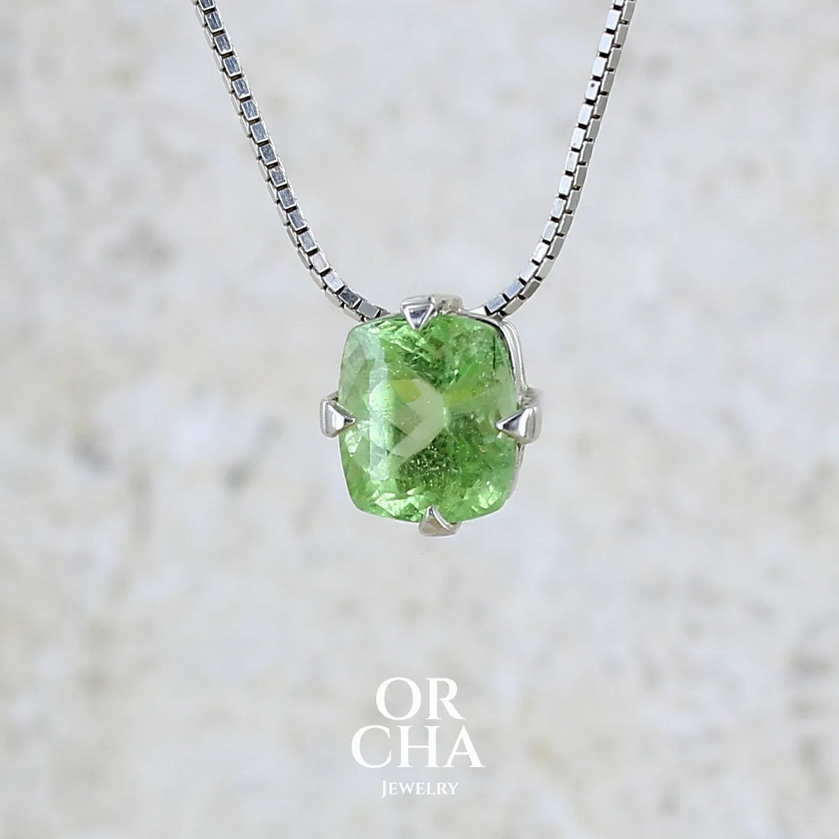 Collier solitaire pour femme en argent massif sertie d'un Péridot de couleur vert pastel anisé. Pierre facettée de forme carrée, qualité transparente présentant des inclusions. Pendentif monté sur une chaine en argent sterling de type maille miroir de 1,3 mm d'épaisseur et de 40cm de longueur. Bijoux unique réalisé par Orchajewelry