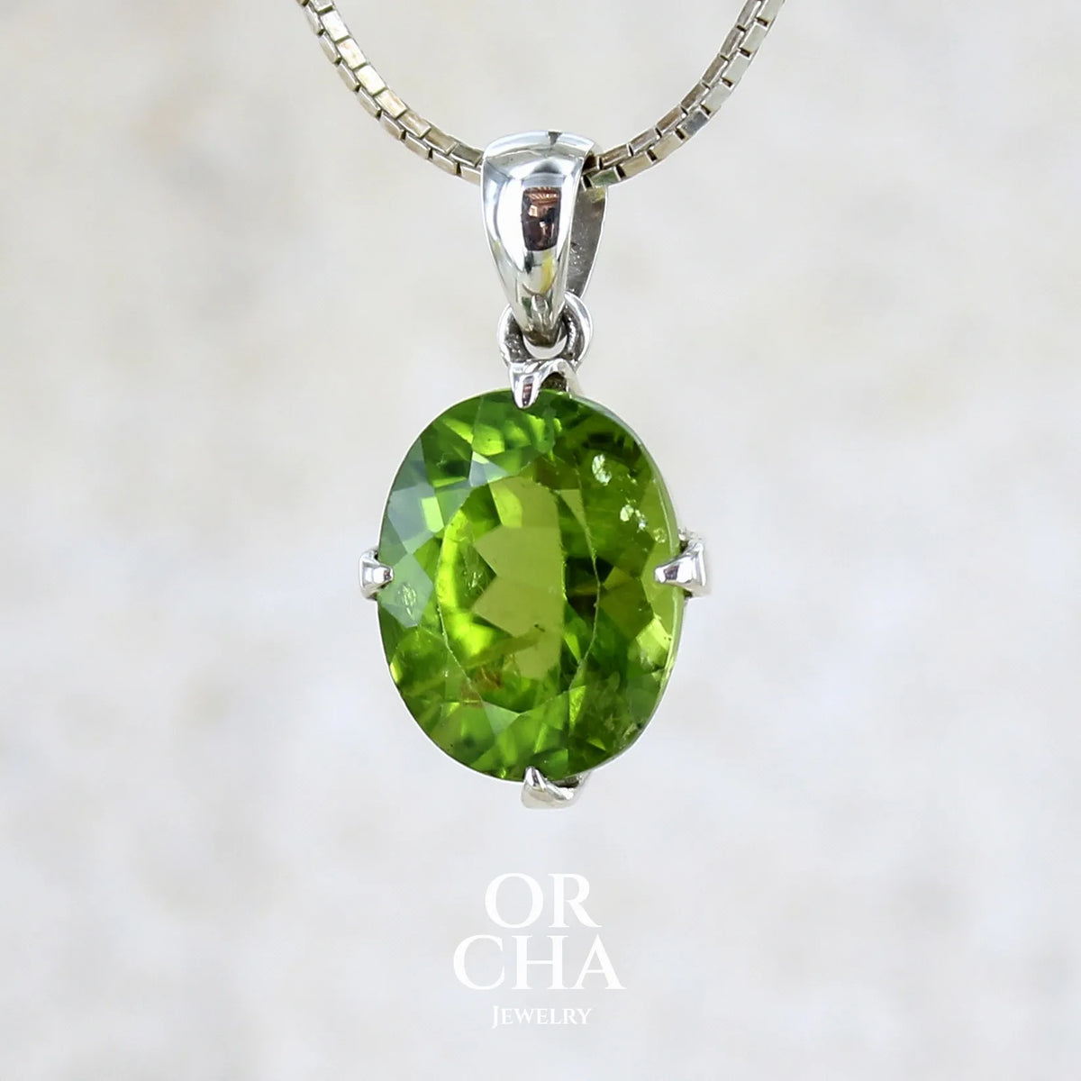 pendentif pour femme en argent massif serti d'un Péridot de couleur vert olive doré profond et intense . Pierre taillée transparente présentant des inclusions, de forme ovale. Bijoux unique par Orchajewelry
