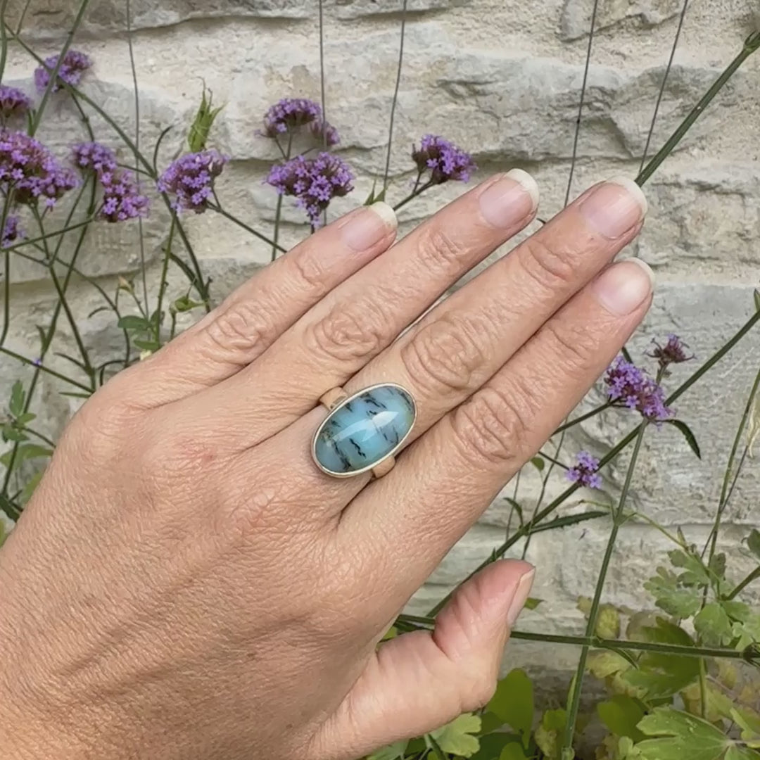 Bague pour femme en argent massif, sertie d'un cabochon ovale d'opale bleue du Pérou de couleur bleu laiteux à inclusions de dendrites noires. Pierre naturelle de qualité opaque et translucide. Bijoux unique réalisé en taille 54,5 - OrchaJewelry