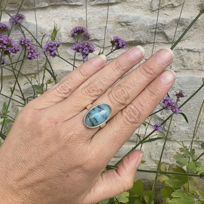 Bague pour femme en argent massif, sertie d'un cabochon ovale d'opale bleue du Pérou de couleur bleu laiteux à inclusions de dendrites noires. Pierre naturelle de qualité opaque et translucide. Bijoux unique réalisé en taille 54,5 - OrchaJewelry
