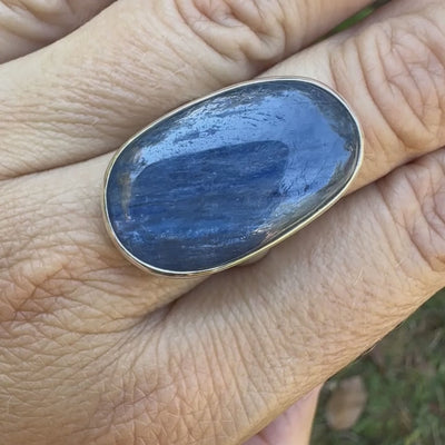 Bague pour femme en argent massif sertie d'un cabochon de cyanite de couleur bleu jean nacré. Pierre translucide à inclusions de forme ovale arrondie. Bijou unique réalisée en taille 58,5 par Orchajewelry