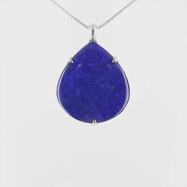 Pendentif goutte en lapis-lazuli bleu profond avec inclusions dorées, serti de trois griffes en argent massif 925. Le bijou,  présente une pierre naturelle polie en forme de goutte, montée sur une bélière sobre. Un bijou artisanal unique mettant en valeur la beauté minérale brute et élégante du lapis-lazuli. Bijoux unique, éthique et durable présenté dans un coffret de notre marque, prêt à offrir. Livraison offerte, certificat d'authenticité, service client.