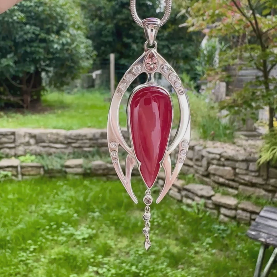 Pendentif exclusif, création originale, pour femme en argent massif serti d'une Rhodonite de très belle qualité, d'une tourmaline et de goshénite. Pierre de couleur rouge coquelicot, rose pastel et blanche, translucide à transparentes. Pierre naturelle, en forme de goutte, taillée en cabochon. Bijoux unique, éthique et durable présenté dans un coffret de notre marque, prêt à offrir. Livraison offerte, certificat d'authenticité, service client