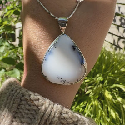 Pendentif pour femme en argent massif sertie d'un cabochon en forme de goutte  d'agate dendritique de couleur blanc pur et noir. Pierre opaque à translucide à inclusions paysages de dendrites de manganèse noires contrastées. Bijou unique réalisé par Orchajewelry