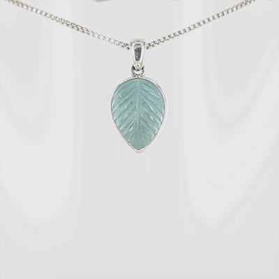 Pendentif pour femme en argent massif serti d'une topaze bleue sculptée en forme de feuille d'arbre. Pierre de couleur bleu ciel lumineux. Bijoux unique, éthique et durable présenté dans un coffret de notre marque, prêt à offrir. Livraison offerte, certificat d'authenticité, service client.