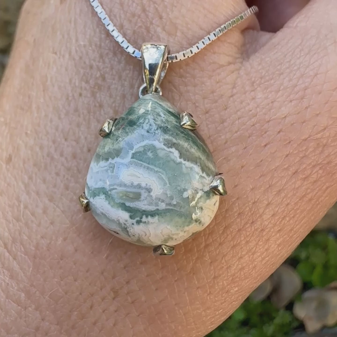 Pendentif pour femme en argent massif sertie d'un cabochon de jaspe océan de couleur nuancée de kaki et crème. Pierre opaque taillée en forme de goutte. Bijou unique par Orchajewelry

