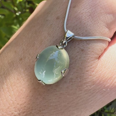 Pendentif ovale en argent massif, serti d'un cabochon de préhnite de couleur  verte clair. Pierre de qualité translucide comportant des inclusions. Bijoux unique par Orcha Jewelry 