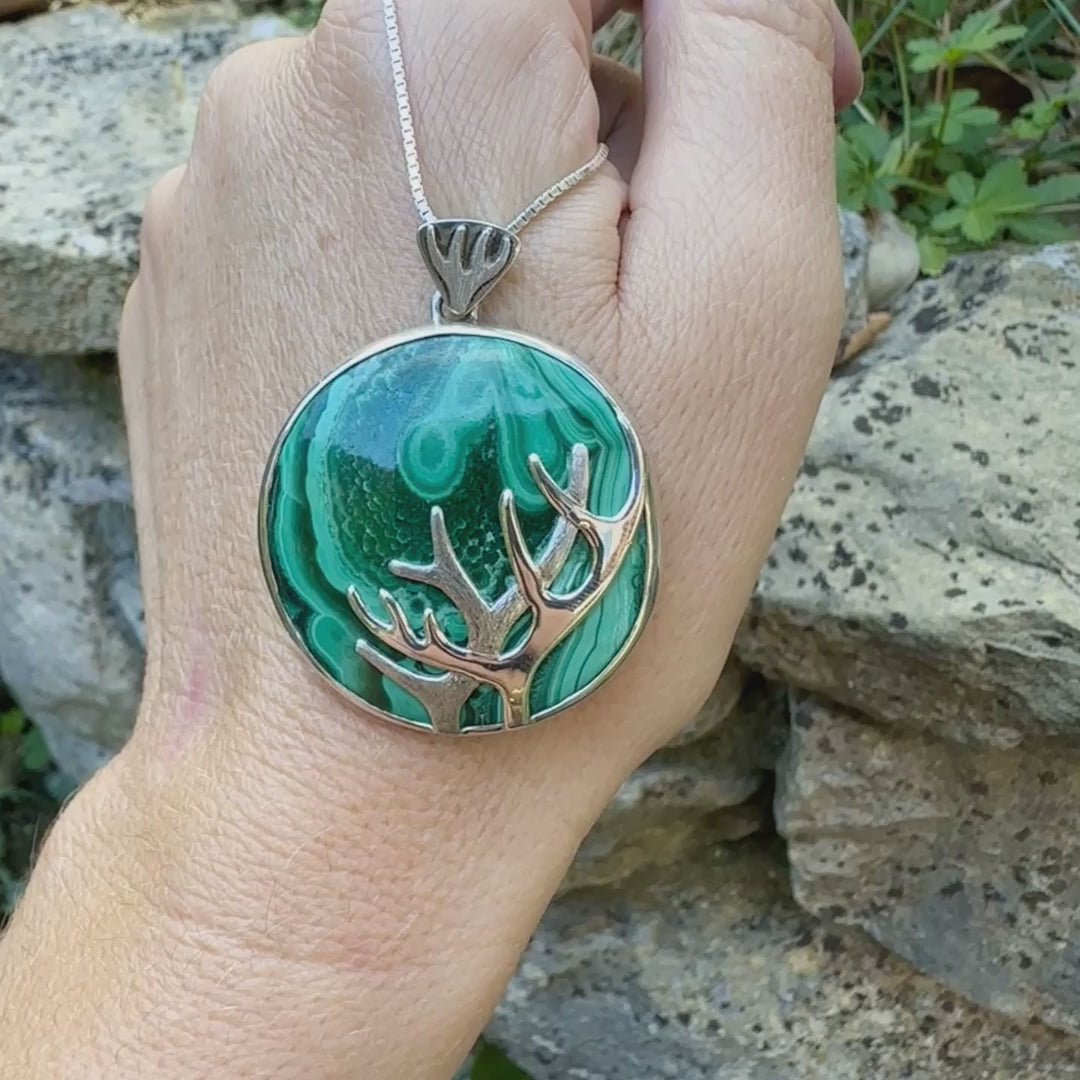 Pendentif de créateur en argent massif, où s'illustre des bois de cerf sculpté en argent massif et serti sur un cabochon de Malachite. Pierre au superbes nuances de verts, pierre opaque naturelle de forme ronde. Bijoux unique réalisé par orchajewelry