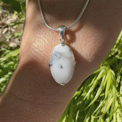 Pendentif pour femme en argent massif sertie d'un cabochon de forme ovale d'agate dendritique de couleur blanc pur et noir. Pierre opaque à translucide à inclusions paysages de dendrites de manganèse noires contrastées. Bijou unique réalisé par Orchajewelry
