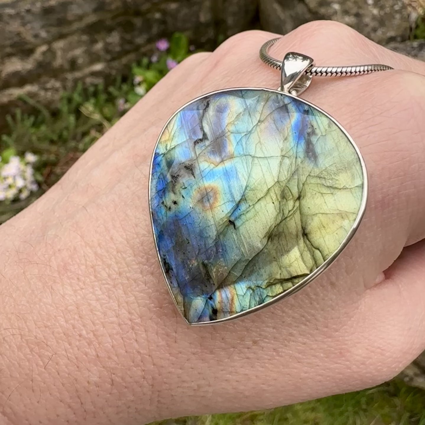 Pendentif pour femme en argent massif sertie d'une labradorite aux reflets bleus et bronze selon la lumière. Pierre facettée naturelle translucide présentant des inclusions fréquents sur ce type de pierre. Bijoux unique, éthique et durable présenté dans un coffret de notre marque, prêt à offrir. Livraison offerte, certificat d'authenticité, service client.