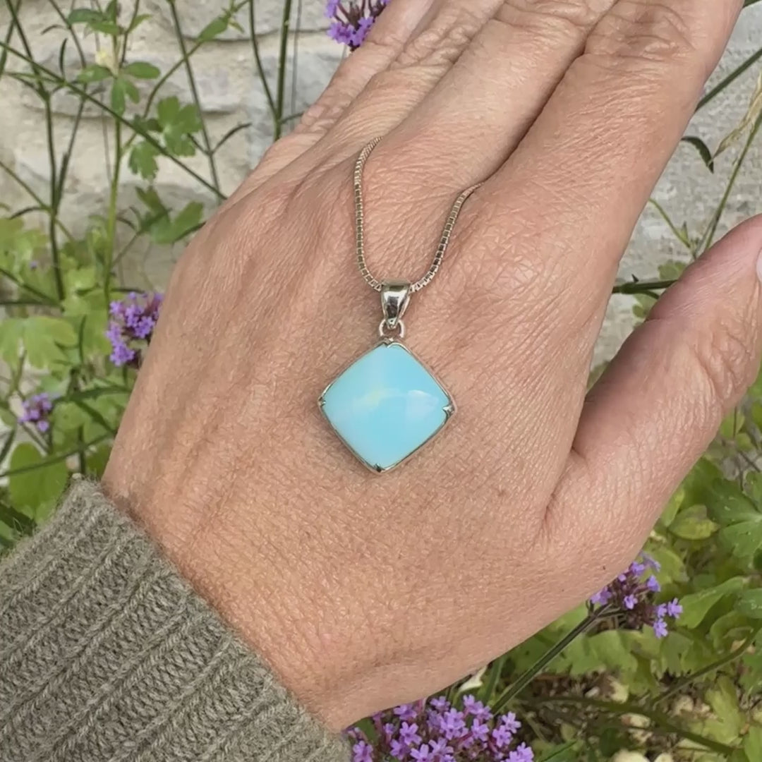 Pendentif en argent massif, sertie d'un cabochon d'opale bleue du Pérou de couleur bleu ciel clair. Pierre de forme carrée. Pierre opaque. Bijoux unique, éthique et durable présenté dans un coffret de notre marque, prêt à offrir. Livraison offerte, certificat d'authenticité, service client.