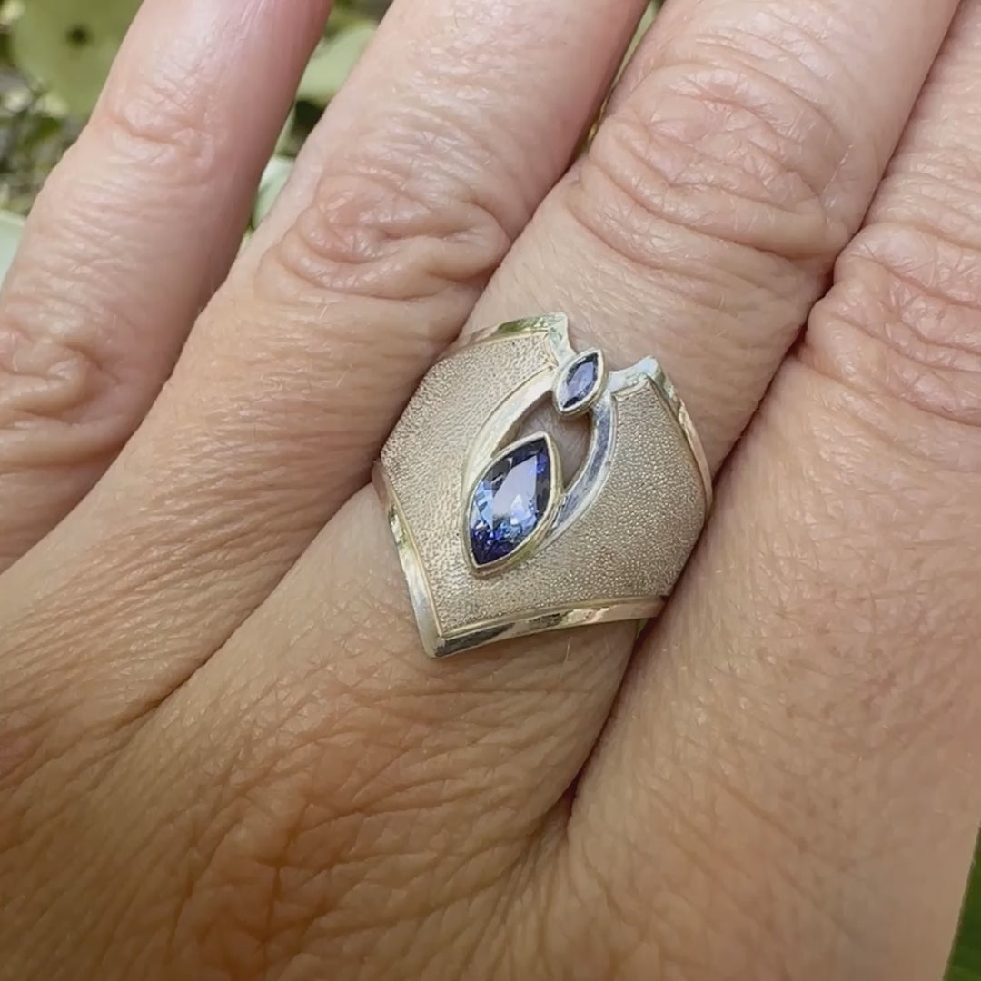 Vidéo d'une bague marquise pour femme, en argent massif sertie de tanzanites bleu lavande. Pierres facettées en forme de navette. Pierre  gemme lumineuse et propre à l'oeil. Taille 55. Bijoux unique, éthique et durable présenté dans un coffret de notre marque, prêt à offrir. Livraison offerte, certificat d'authenticité, service client.