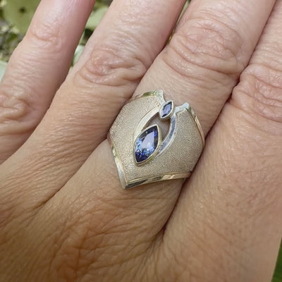 Vidéo d'une bague marquise pour femme, en argent massif sertie de tanzanites bleu lavande. Pierres facettées en forme de navette. Pierre  gemme lumineuse et propre à l'oeil. Taille 55. Bijoux unique, éthique et durable présenté dans un coffret de notre marque, prêt à offrir. Livraison offerte, certificat d'authenticité, service client.