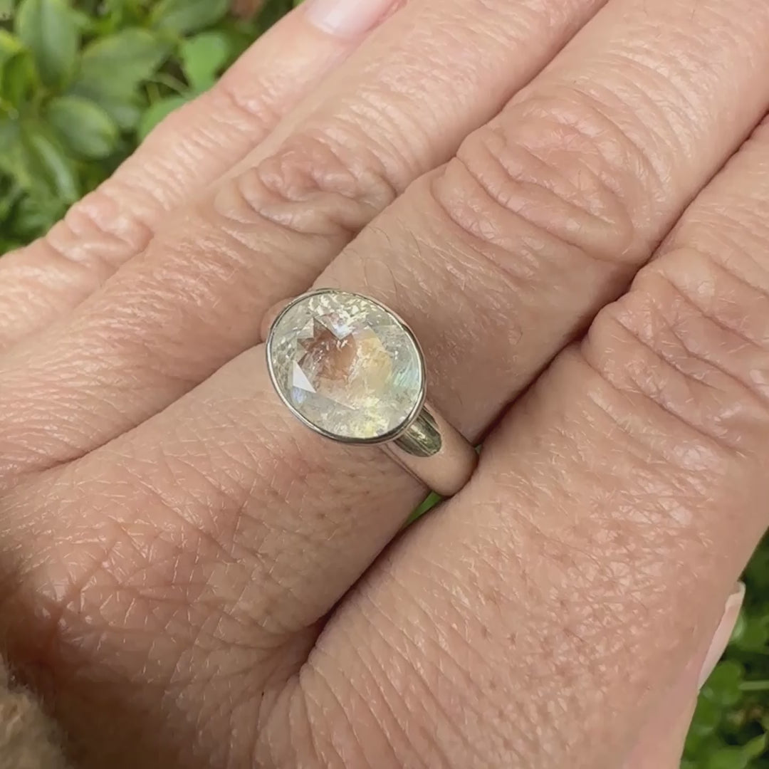 Bague cocktail pour femme en argent massif 925 sertie d'une pierre de lune arc en ciel de Madagascar taillée de 2,5 carats incolore aux reflets bleutés et arc en ciel. Pierre transparente avec inclusions. Bijoux unique réalisée en taille 56 par Orchajewelry