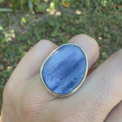 Bague pour femme en argent massif sertie d'un cabochon de cyanite de couleur bleu jean nacré. Pierre translucide à inclusions. Bijou unique réalisée en taille 54 par Orcha Jewelry