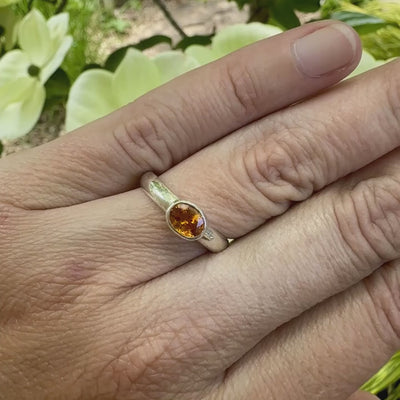 Vidéo d'une bague anneau en argent massif sertie d'un Saphir orange. Pierre facettée de forme ovale de qualité transparente, propre à l'oeil. Pierre chauffe et traité au beryllium de couleur orange intense. Tailles 56. Pour homme et femme. Bijoux unique, éthique et durable présenté dans un coffret de notre marque, prêt à offrir. Livraison offerte, certificat d'authenticité, service client.