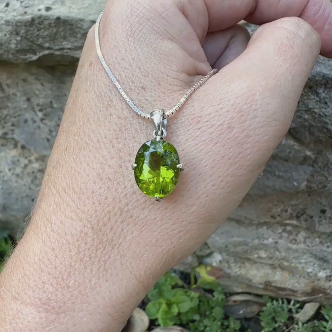 pendentif pour femme en argent massif serti d'un Péridot de couleur vert olive doré profond et intense . Pierre taillée transparente présentant des inclusions, de forme ovale. Bijoux unique par Orchajewelry
