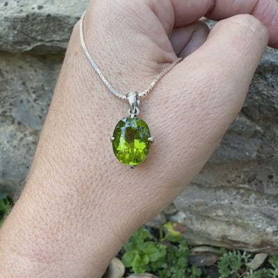 pendentif pour femme en argent massif serti d'un Péridot de couleur vert olive doré profond et intense . Pierre taillée transparente présentant des inclusions, de forme ovale. Bijoux unique par Orchajewelry