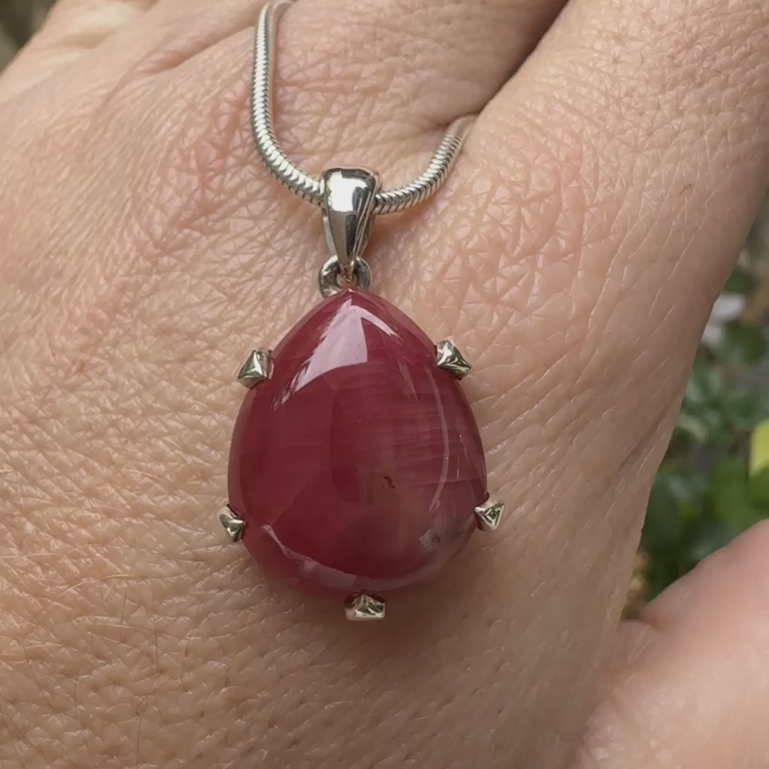Pendentif pour femme en argent massif  serti d'une Rhodonite de belle qualité. Pierre de couleur rouge coquelicot, opaque à inclusions. Pierre naturelle, en forme de goutte, taillée en cabochon. Bijoux unique, éthique et durable présenté dans un coffret de notre marque, prêt à offrir. Livraison offerte, certificat d'authenticité, service client