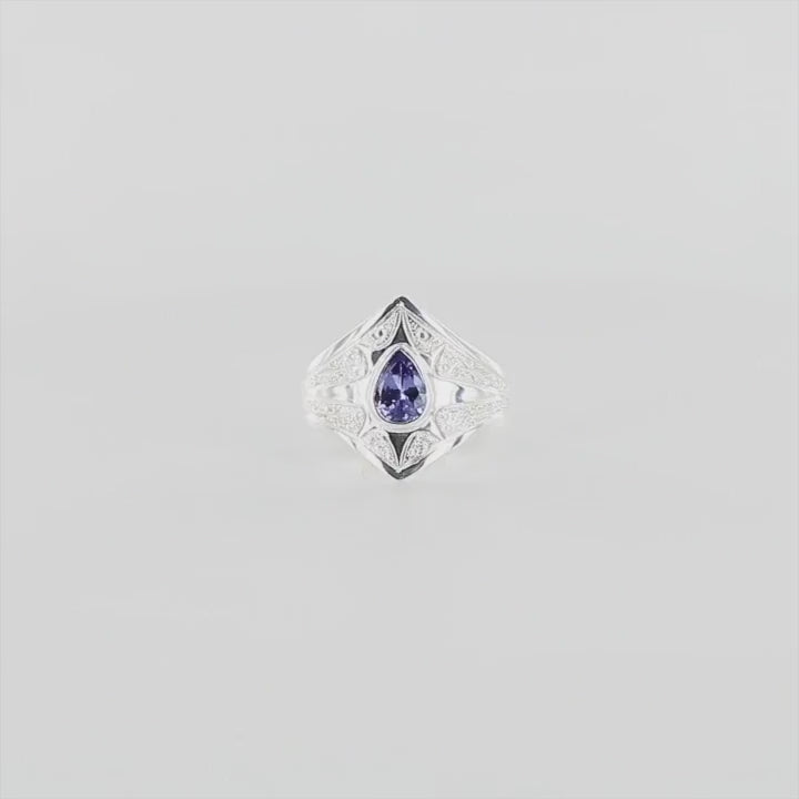 Bague pour femme en argent massif sculptées d'étoiles et autres corps célestes sertie d'une Tanzanite. Pierre facettée en forme de goutte, pierre naturelle de couleur bleu lavande . Qualité  transparente, propre à l'oeil. Taille 59. Bijoux unique, éthique et durable présenté dans un coffret de notre marque, prêt à offrir. Livraison offerte, certificat d'authenticité, service client.
