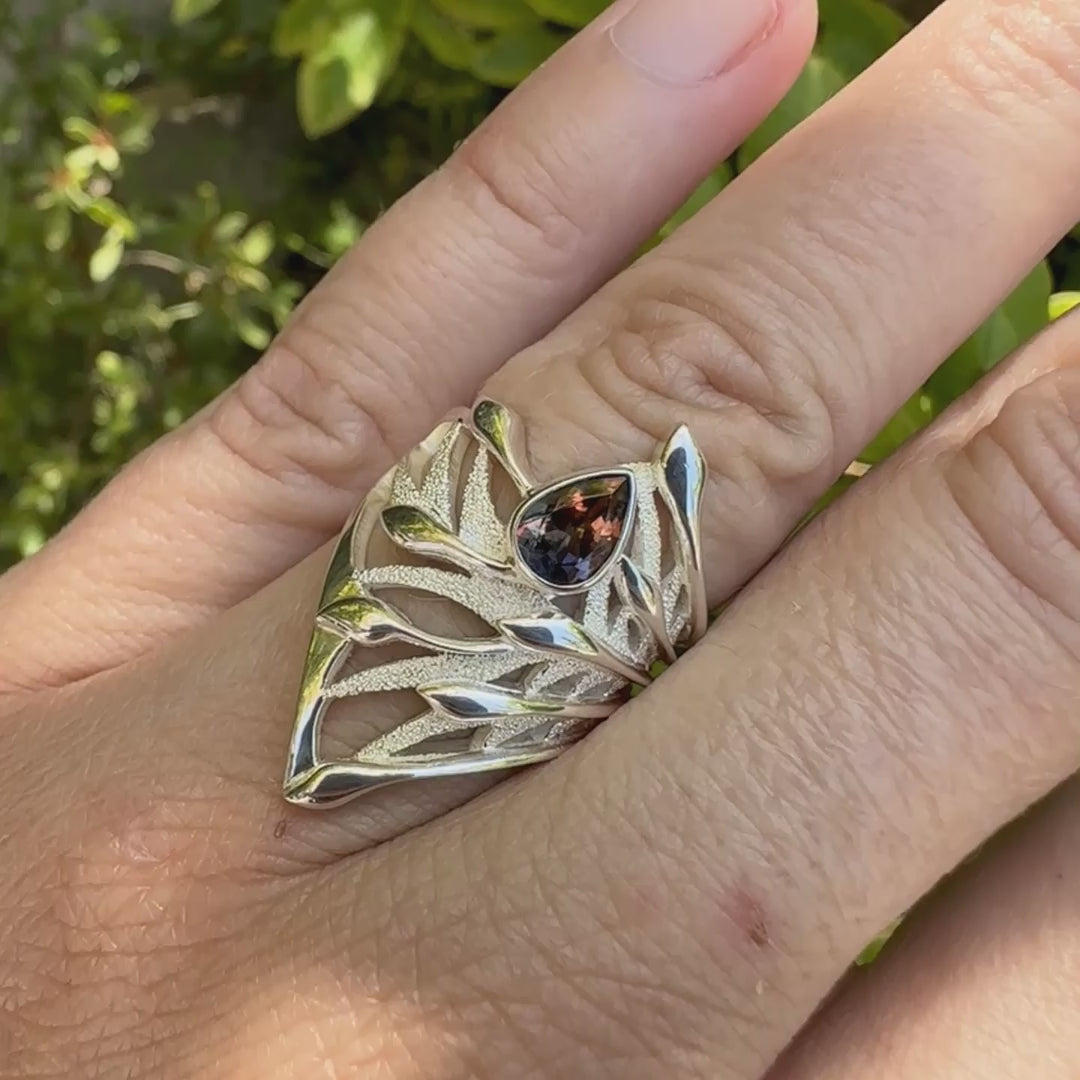 Grande Bague pour femme en argent massif, sertie d'une Tourmaline bicolore rose pêche et bleue nuit. Pierre facettée en forme de goutte. Pierre incolore, très lumineuse et propre à l'oeil. Bijoux unique au design de feuillage tropicale travaillé en filigrane réalisé en taille 54.