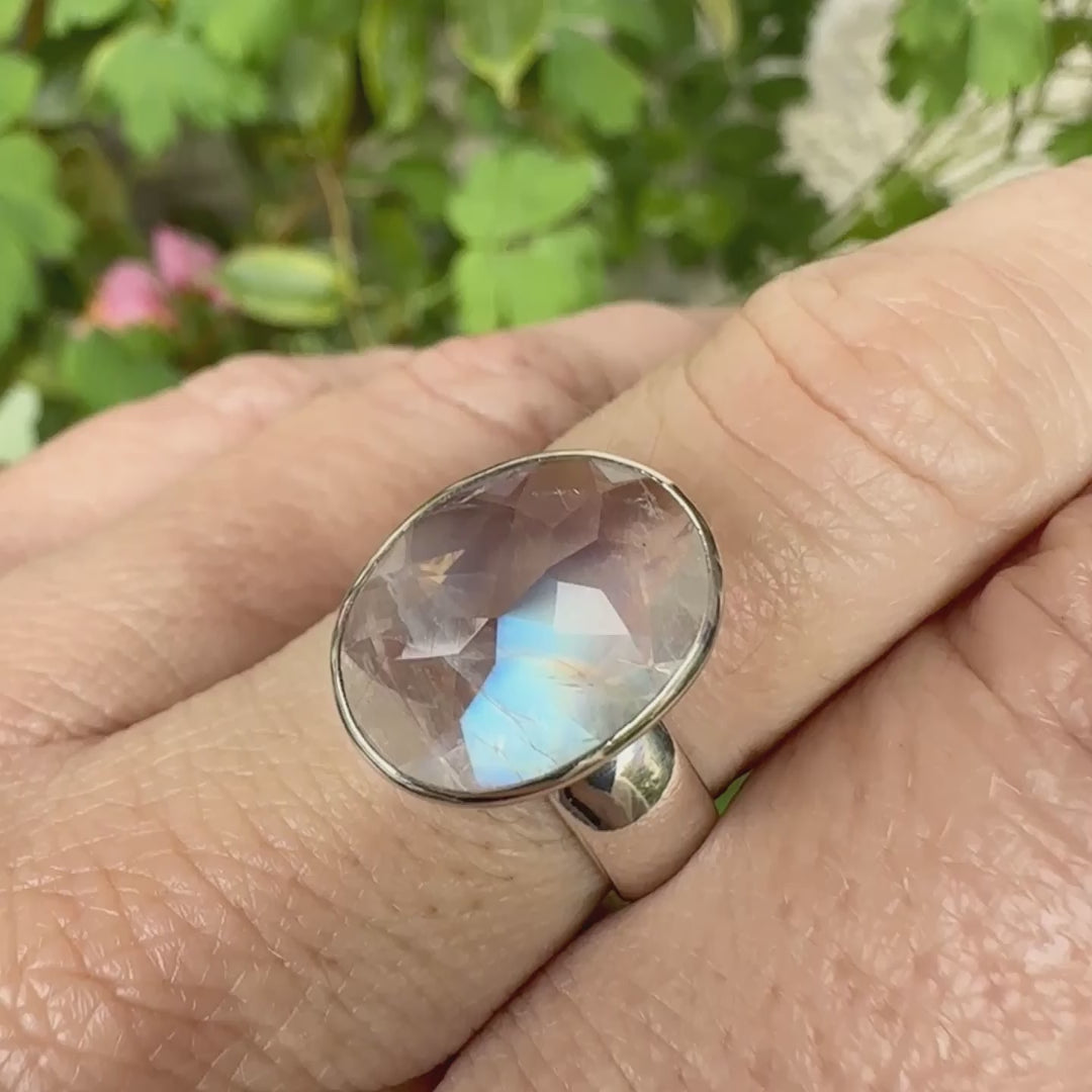 Bague cocktail pour femme en argent massif 925 sertie d'une Labradorite blanche taillée de 6,7 carats incolore aux reflets bleutés et arc en ciel. Pierre transparente avec inclusions. Bijoux unique réalisée en taille 57 par Orchajewelry