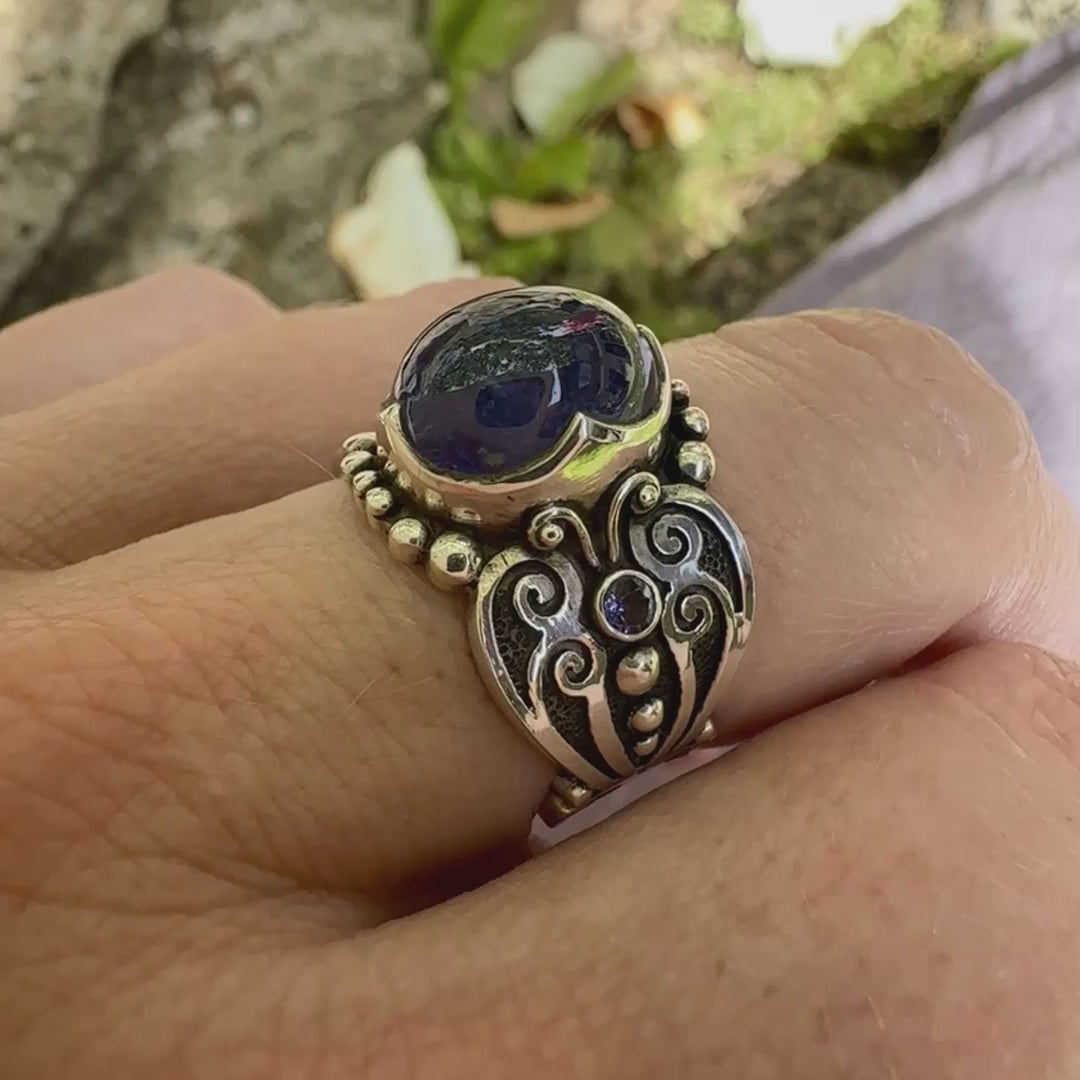 Bague en argent massif sculptées d'entrelacs de style celtique qui illustrent des papillons, sertie d'une Tanzanite. Pierre cabochon de forme ovale, de couleur bleu lavande foncé, de qualité transparente avec inclusions. Taille 56. Bijoux unique, éthique et durable présenté dans un coffret de notre marque, prêt à offrir. Livraison offerte, certificat d'authenticité, service client.

