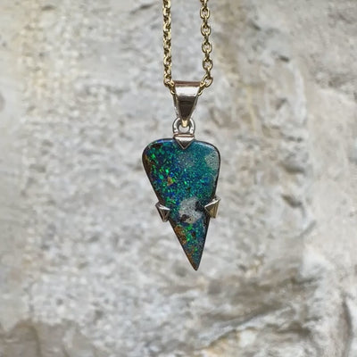 Pendentif pour homme en or 9k et argent massif 925 serti d'une opale boulder aux feux multicolores bleus et verts. Tranche d'opale massive naturelle taillée en forme d'aile. Pierre de qualité opaque originaire d'Australie. Bijoux unique par Orcha Jewelry.
