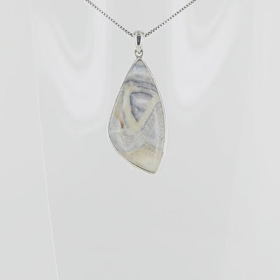 Pendentif  pour femme en argent massif sertie d'une scheelite bleue. Pierre naturelle de couleur bleu, beige crème et blanc de qualité  opaque. Bijoux unique, éthique et durable présenté dans un coffret de notre marque, prêt à offrir. Livraison offerte, certificat d'authenticité, service client.
