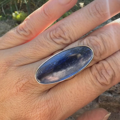 Grande Bague pour femme en argent massif, sertie d'un long cabochon ovale de cyanite de couleur bleu denim nacré. Pierre de qualité translucide. Bijou unique réalisée en taille 58 par Orcha jewelry