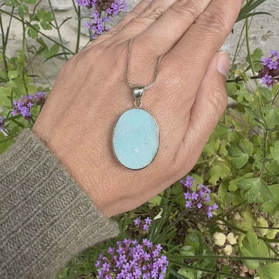 Pendentif pour femme en argent massif sertie d'un magnifique gemsilica druzy, chrysocolle silicifiée recouverte de fins cristaux de quartz scintillant. Pierre de qualité opaque taillée en tranche de forme ovale. Pierre naturelle originaire de République dominicaine du Congo de couleur bleu clair turquoise. pierre rare et unique
