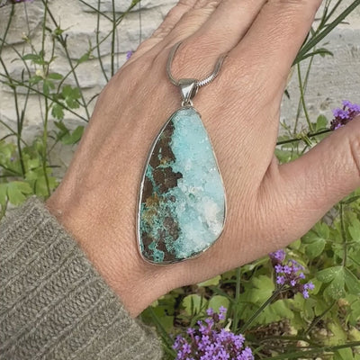 Pendentif en argent massif serti d'un magnifique gemsilica druze: chrysocolle silicifiée recouverte de fins cristaux de quartz scintillant. Pierre de qualité opaque brute en forme de goutte. Pierre naturelle originaire du Mexique de couleur bleue ciel turquoise claire.
