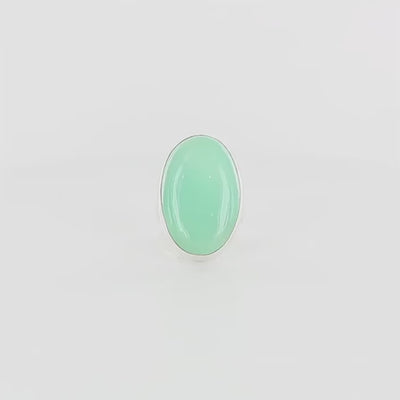 Grande bague contemporaine pour femme en argent massif sertie d'une Chrysoprase. Pierre cabochon de forme ovale de qualité opaque à translucide. Pierre naturelle de couleur vert bleuté lumineux. réalisée en taille 58. Bijoux unique, éthique et durable présenté dans un coffret de notre marque, prêt à offrir. Livraison offerte, certificat d'authenticité, service client.