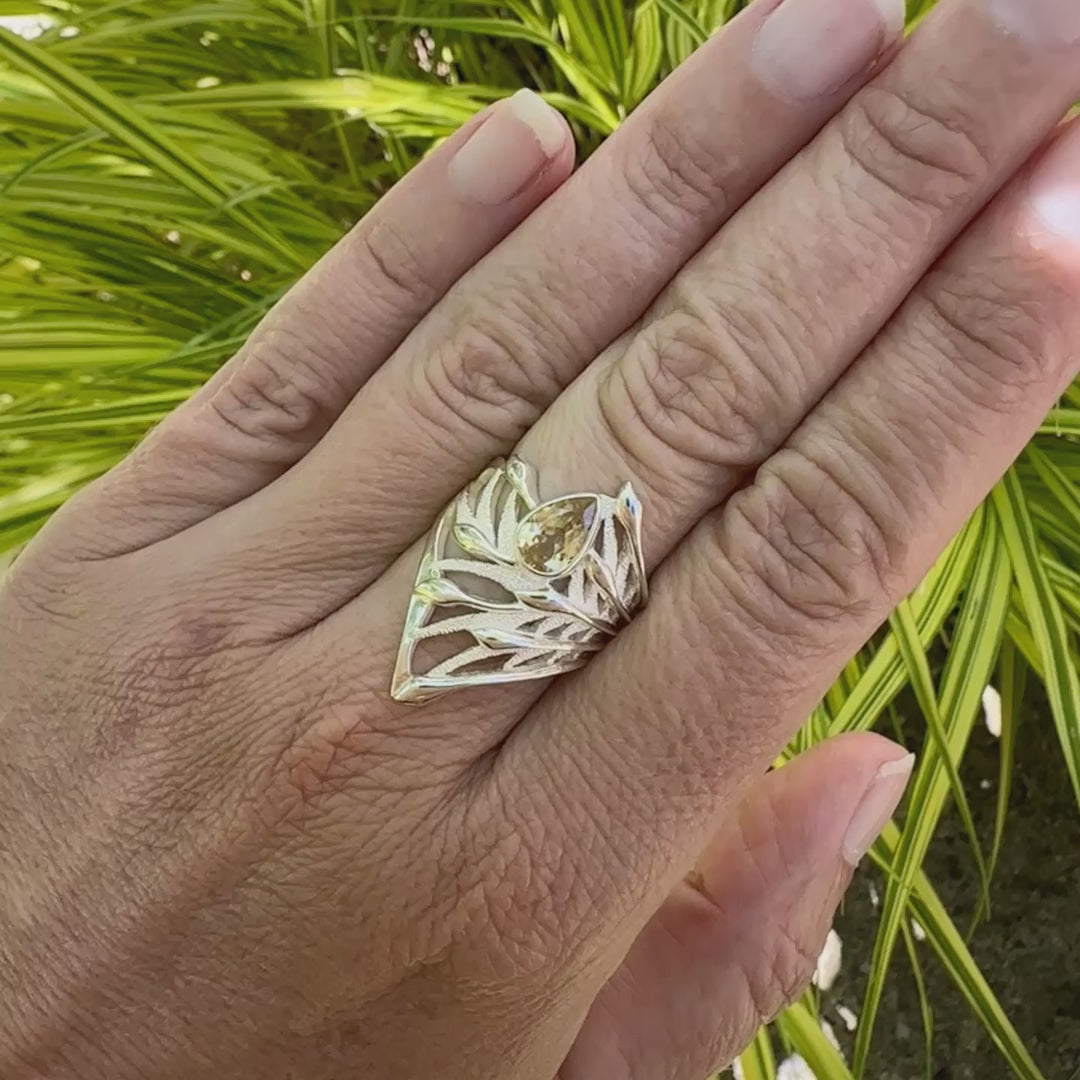 vidéo d'une Grande Bague topaze impériale et argent massif illustrant un feuillage tropicale. Bijou pour femme sertie d'une Topaze impériale de couleur jaune pâle doré, pierre  facettée en forme de poire. Pierre très lumineuse et propre à l'oeil. Bijoux unique, éthique et durable présenté dans un coffret de notre marque, prêt à offrir. Livraison offerte, certificat d'authenticité, service client.
