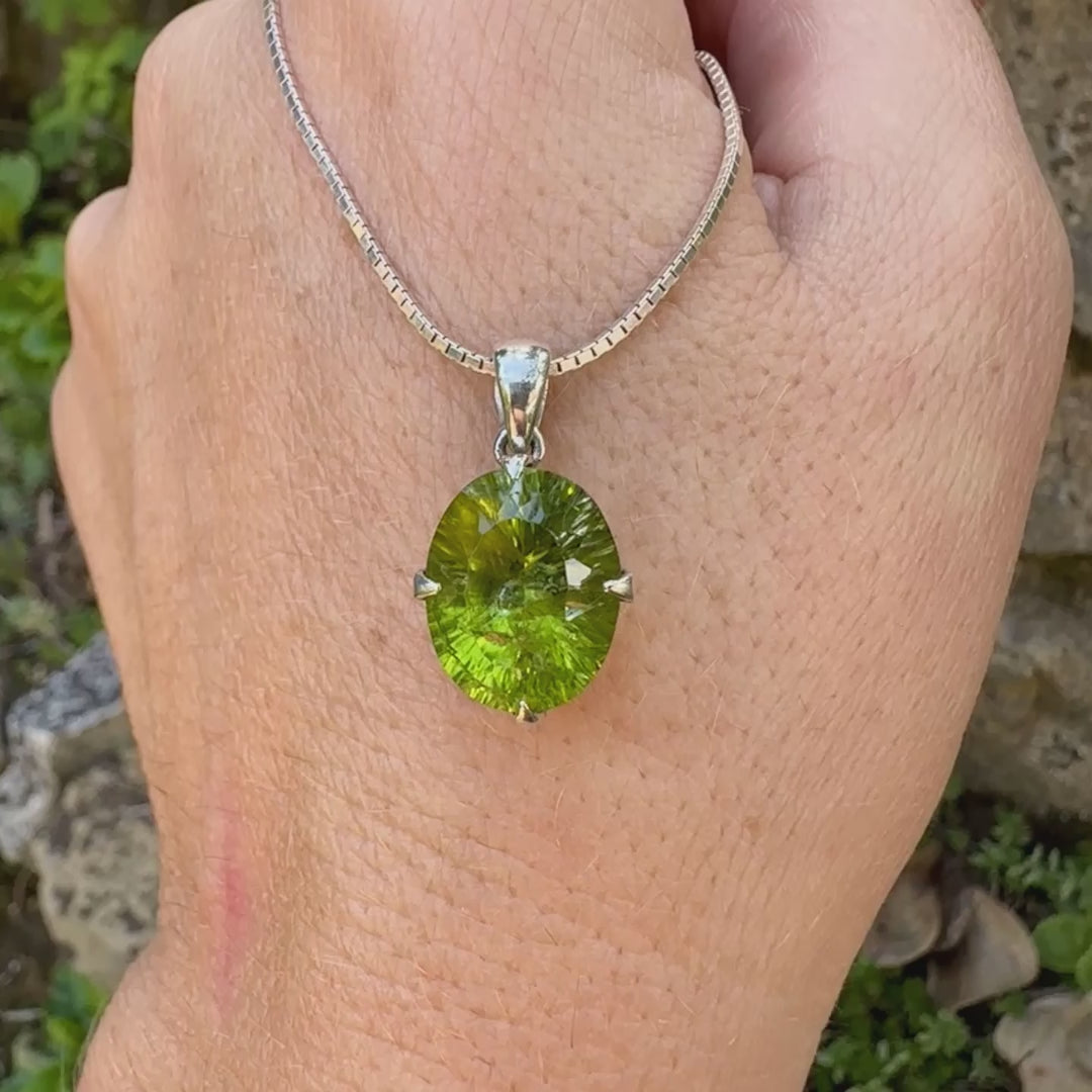 Pendentif pour femme en argent massif serti d'un péridot de couleur vert olive doré intense. Pierre taillée "laser cut", de forme ovale, transparente présentant de nombreuses inclusions. Bijou unique réalisé par Orchajewelry