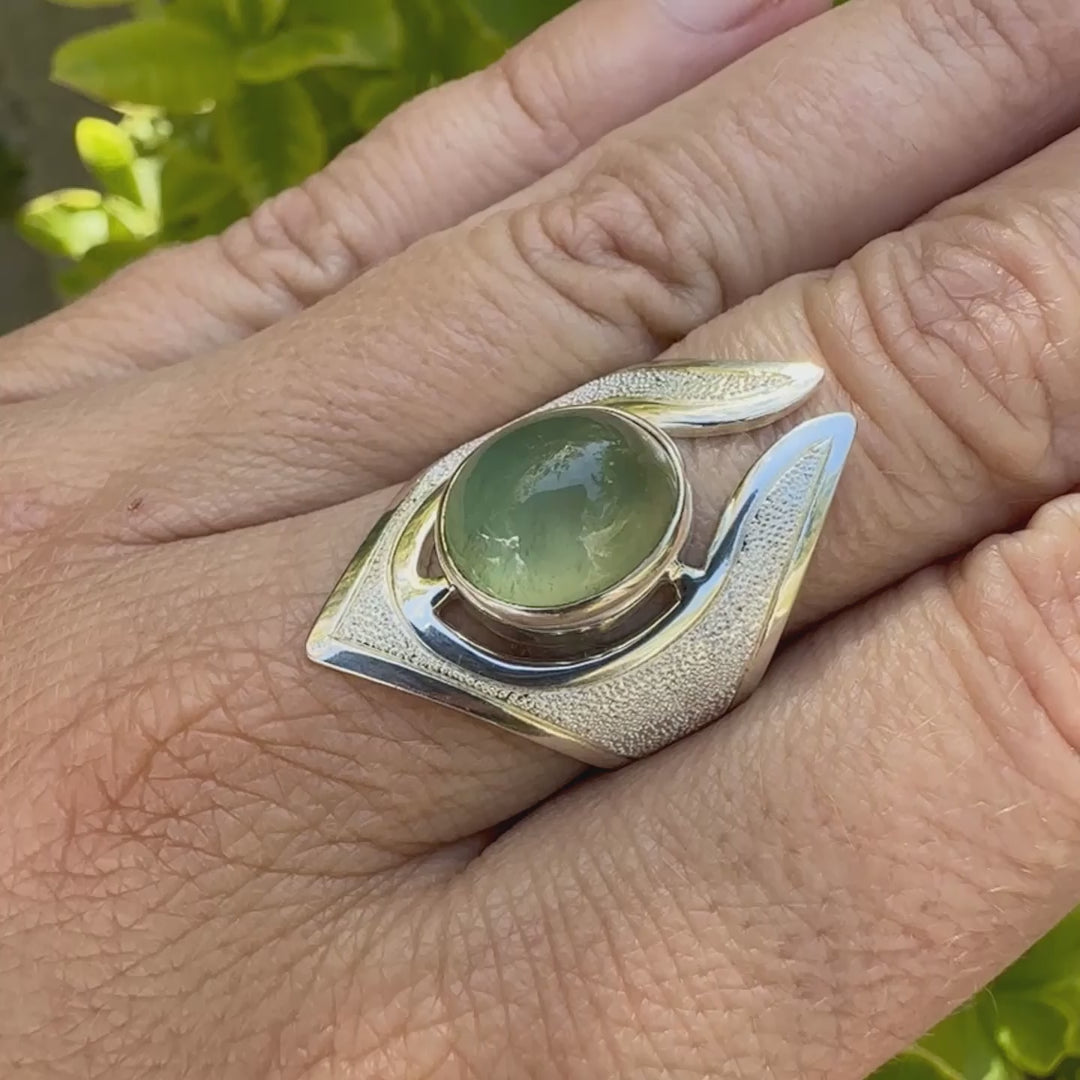 Grande bague pour femme en argent massif sertie d'une préhnite de couleur verte jaune clair, Pierre taillée en cabochon en forme de goutte. Pierre gemme de qualité transparente à inclusions. Bijoux unique réalisé en taille 59 par Orchajewelry.