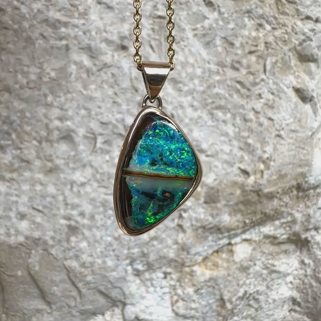 Pendentif pour femme en or 9k massif et argent massif 925 serti d'une opale boulder aux feux multicolores à dominantes bleu turquoise et vert et de six diamants. Pierre cabochon de qualité opaque taillée en forme d'aile. Bijou unique par Orchajewelry