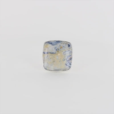 Bague carrée pour femme en argent massif sertie d'une scheelite bleue. Pierre naturelle de couleur bleu, beige creme et blanc de qualité  opaque. Taille 60. Bijoux unique, éthique et durable présenté dans un coffret de notre marque, prêt à offrir. Livraison offerte, certificat d'authenticité, service client.