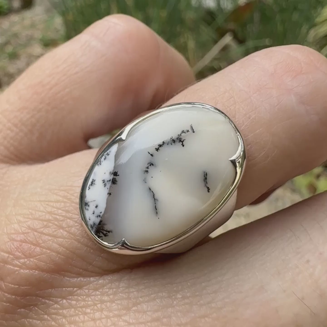 Bague pour femme en argent massif sertie d'un cabochon ovale d'agate dendritique de couleur blanc pur et noir. Pierre opaque translucide à inclusions paysages de dendrites de manganèse noires contrastées. Bijou unique réalisé en taille 54 par Orchajewelry